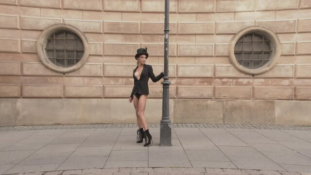 Posing Dancer Touching Top Hat On Pavement