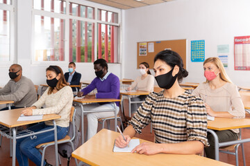 Portrait of asian woman in protective face mask during lesson in school for adults. Concept of...