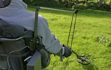 Disabled man Wheelchair user metal detecting for coins field