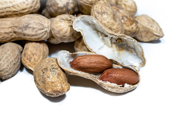 a pile of peanuts in the shell and without on a white background