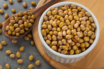 Bowl with string bean grains. Detail of wooden spoon and bamboo support.
