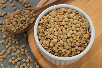 Bowl with lentil grains. Detail of wooden spoon and bamboo support.