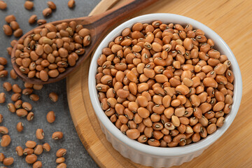 Bowl with ball bean grains. Detail of wooden spoon and bamboo support.