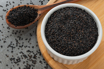 Bowl with black sesame seeds. Detail of wooden spoon and bamboo holder.