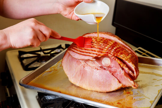 Preparing holiday spiral sliced pork ham with honey glaze.