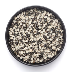 Macro Close up of Organic split black urad dal (Vigna mungo) with the shell on a ceramic black bowl. Top view 