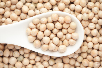 Macro Close up of Close up of Organic dry peas whole (Pisum sativum) or matar dal on a white ceramic soup spoon. Top view