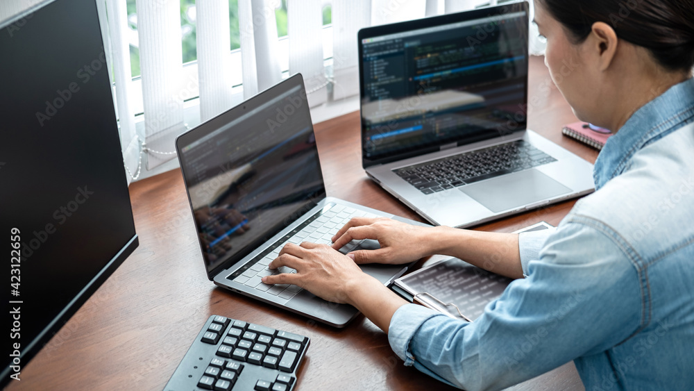 Aufkleber asian programmer woman looking on multiple computer screen to typing coding database and development