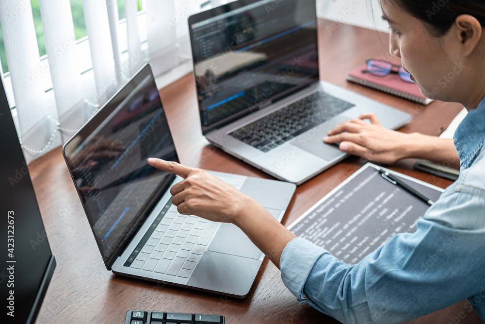 Aufkleber asian programmer woman pointing and looking on multiple laptop screen to writing code and database