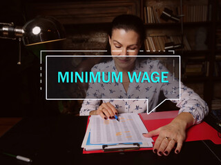  MINIMUM WAGE text in block of quotes. Modern Banker doing paperwork A minimum wage is the lowest...