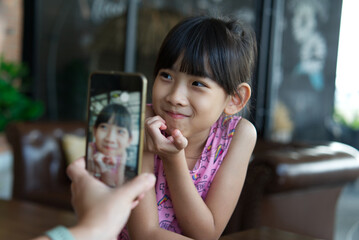 asian child girl Take pictures from the phone Happy fun	