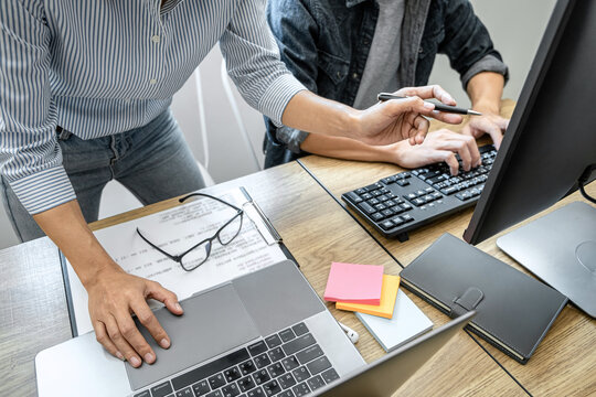 Two professional programmer cooperating and working on web site project in a software developing on desktop computer at company, codes and typing data code, Programming with HTML, PHP and javascript
