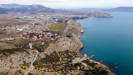 Fototapeta premium Coast of the Crimea peninsula, rocky mountains, aerial view of the sea resort Sudak,