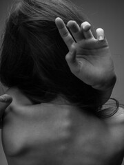 The woman in the gray photograph is touching herself with her bare back