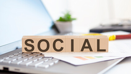 SOCIAL Wooden cubes with letters on a laptop keyboard.