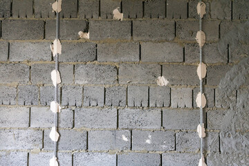Installation of beacons for plaster walls. The wall of expanded clay blocks with installed beacons is ready for plaster.