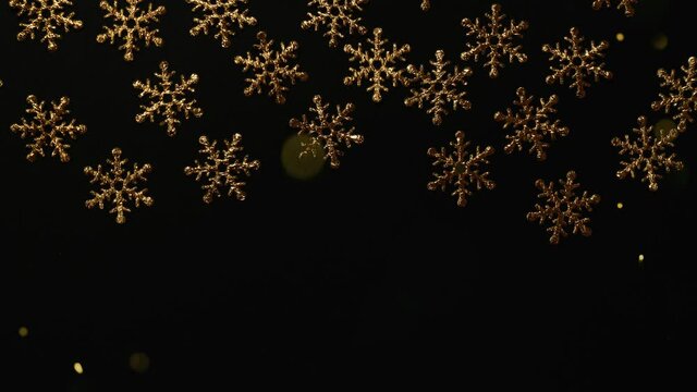 Christmas ornament frame on black, golden snow flakes , flying glitter particles