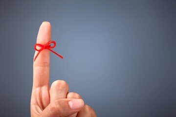 Red thread bow on a human finger