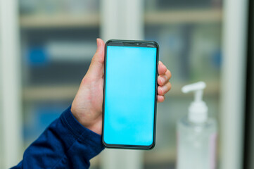 Hand held smartphone: man using phone with green and blue mock-up screen chroma key and scrolling and tapping the screen 