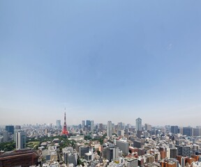 Beautiful city skyline of Downtown Tokyo, with the famous landmark Tokyo Tower standing tall among crowded skyscrapers under blue sunny sky in Tokyo, Japan ~ Aerial view of busy Tokyo Downtown