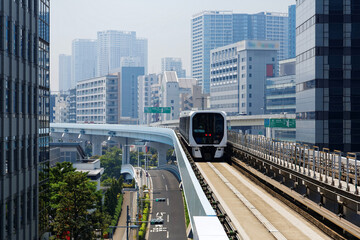 Scenic view of a train traveling on elevated rails of Yurikamome Line in Downtown Tokyo, with a...