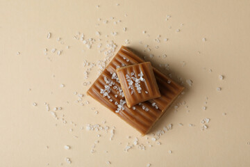 Delicious salted caramel on beige background, top view