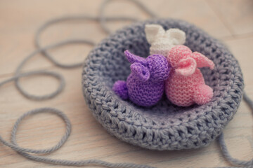 pink, lilac, white handmade bunnies are sitting in a basket