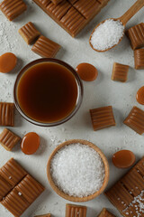 Fototapeta na wymiar Concept of sweet food with caramel pieces, salt and caramel sauce on white textured background