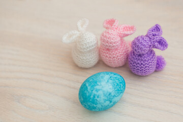 Fototapeta na wymiar handmade pink, purple and white bunnies with blue egg, easter