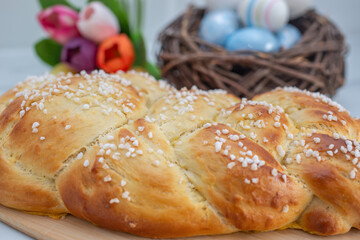 Sweet home made braided yeast bun for easter on a table