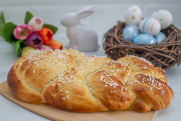 Sweet home made braided yeast bun for easter on a table