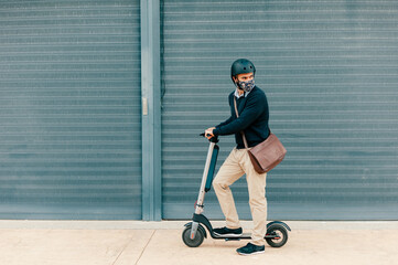Man driving an electric scooter in the city wearing mask