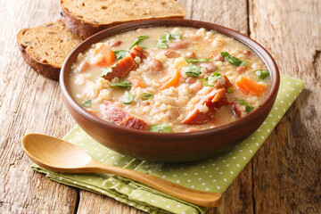 Delicious ricet dish barley and bean with meat and vegetables close-up in a bowl on the table. horizontal