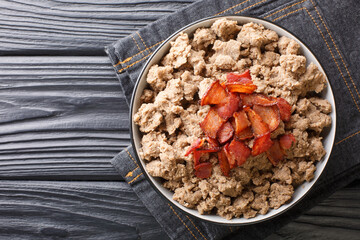 Fototapeta premium Popular food from Slovenia Ajdovi zganci made from buckwheat flour and fried bacon close-up in a bowl on the table. horizontal top view from above