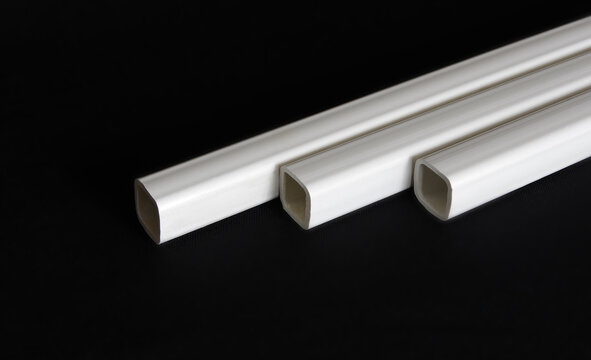 Square pipe PVC white 22x22 on a black background. It is used for installation of nipple watering systems for chickens, broilers and other poultry. Selective focus with copy space.