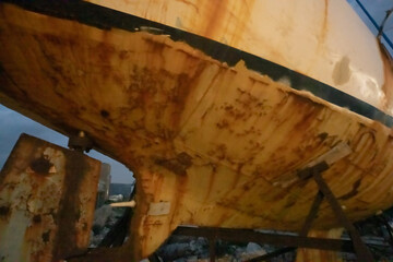 desolate and wrecked sailing yacht at a dry dock in the evening © Erich