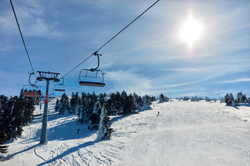 Fototapeta na wymiar Empty ski chair lift on a mountain - season with no tourists.