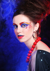 Portrait of young brunette woman with artistic make-up and hair style, close up.