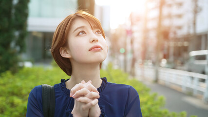 空を見上げて祈る女性