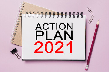 Text ACTION PLAN 2021 on a white notepad with office stationery background. Flat lay on business, finance and development concept