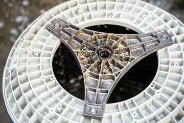 Closeup of the base of the washing machine tub that was removed for cleaning. Lots of dirt build up on the components of the washing machine.