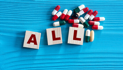 ALL - acronym on wooden cubes on a blue background with tablets