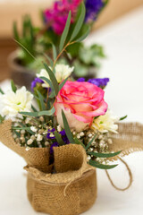 Beautiful flower arrangement in a pot wrapped in burlap.