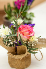Obraz na płótnie Canvas Beautiful flower arrangement in a pot wrapped in burlap.