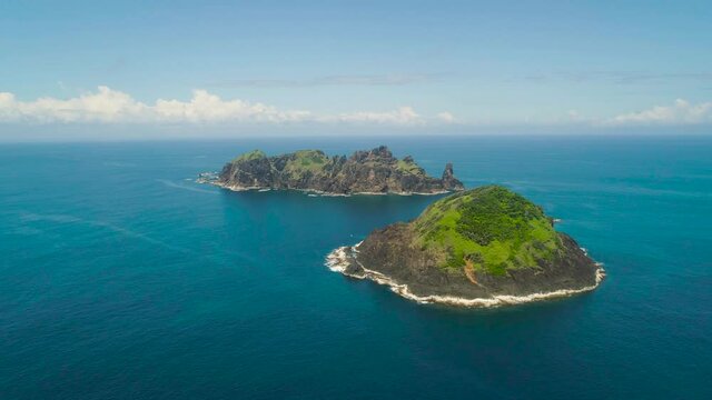 Small rocky islands in the blue sea. Aerial view of seascape with tropical islands in the ocean. Dos Hermanas, Palau, Santa Ana.