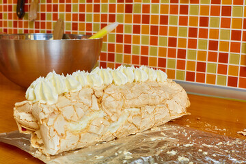 ready delicious sweet roll is on the table on foil on the background of a colored mosaic and a metal bowl
