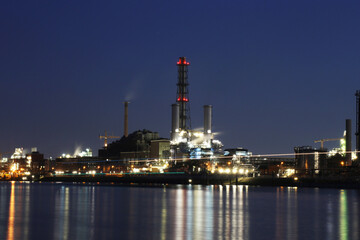 Obraz premium Abendaufnahme von der BASF in Ludwigshafen mit dem Rhein im Vordergrund