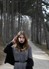 Fototapeta premium red-haired woman looking at the camera on the background of a tree, park, nature.