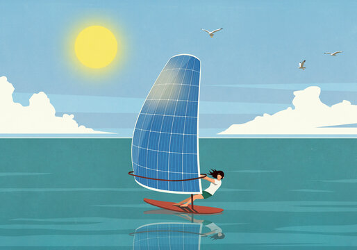 Woman windsurfing with solar panel sail on sunny ocean
