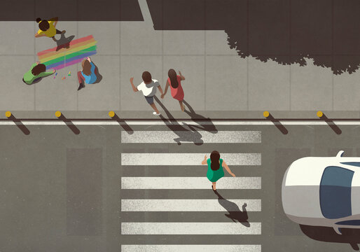 View from above pedestrians crossing street by kids coloring rainbow on sidewalk
